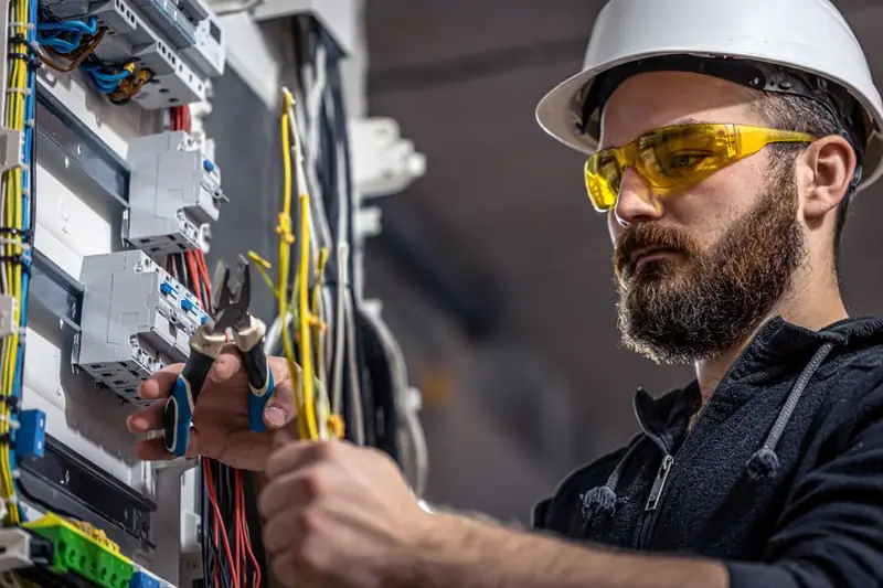 Técnico de AR trabajando en un tablero eléctrico